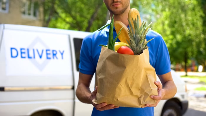 Man delivering groceries in a paper bag