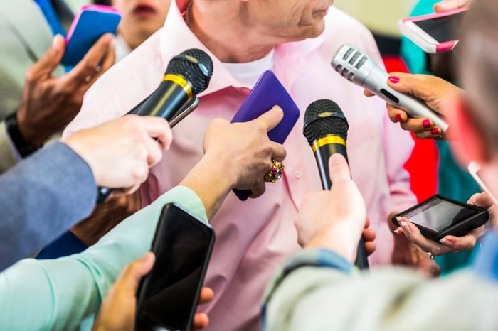 Reporters interviewing a person. 