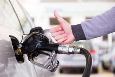 man filling car with gas and giving thumbs up