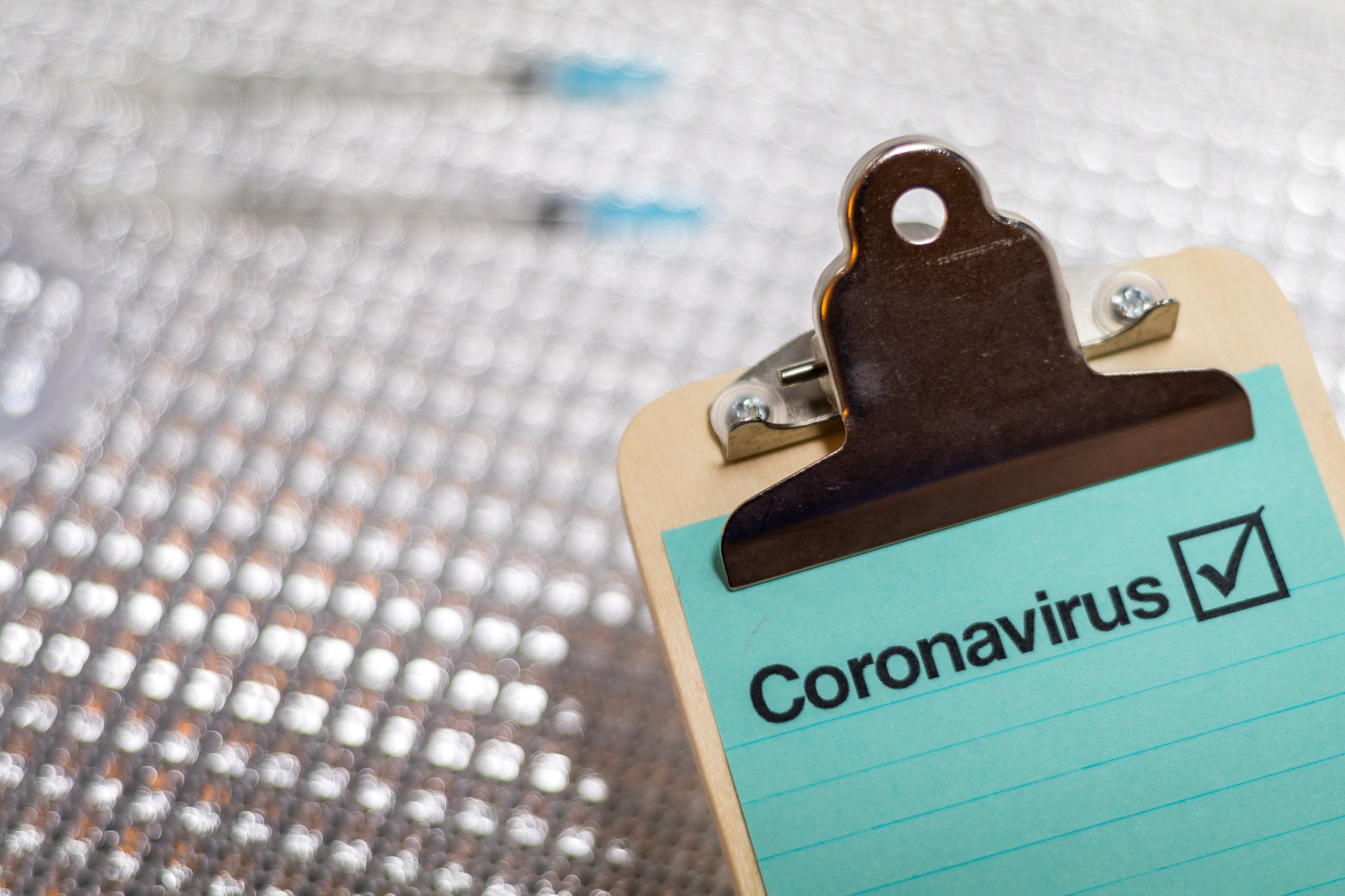 Clipboard with a sheet of paper and the word "Coronavirus" written on it.
