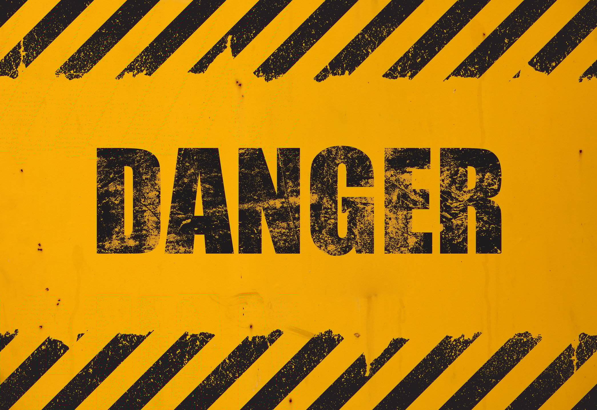 A yellow and black sign that says the word Danger. 