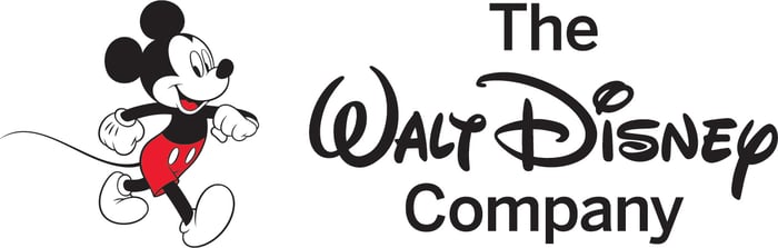 Disney's corporate logo next to a walking Mickey Mouse.