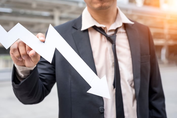 Person holding a downward sloping arrow.