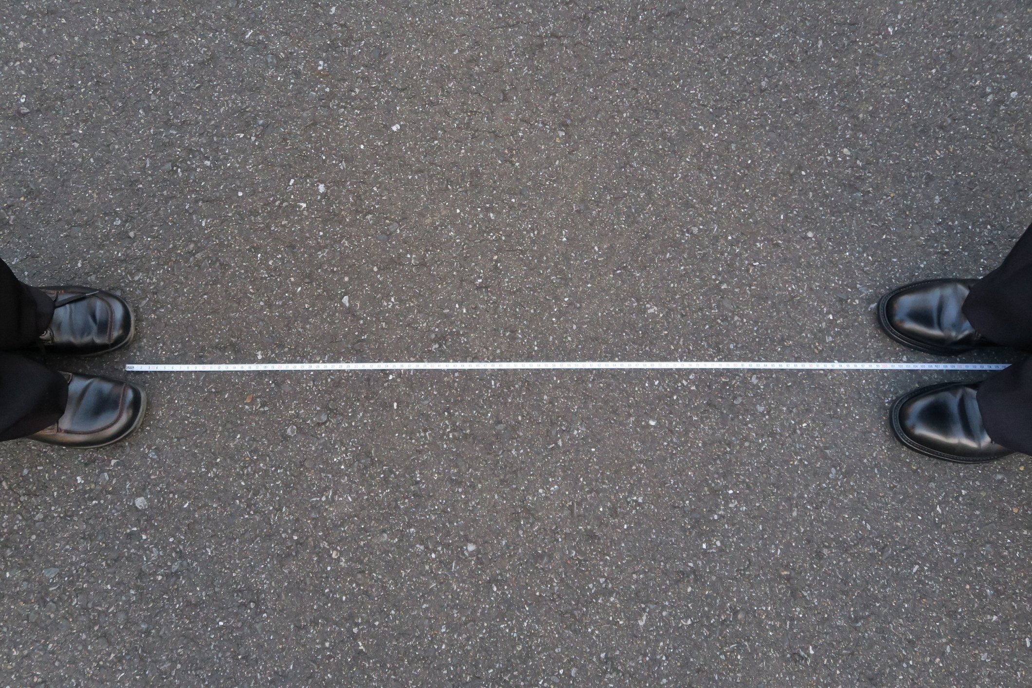 Two people standing several feet apart from each other.