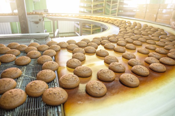 Baked goods on an industrial conveyor belt.