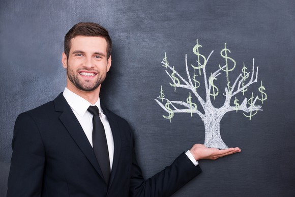 Smiling man in front of chalkboard with sketch of dollar tree,