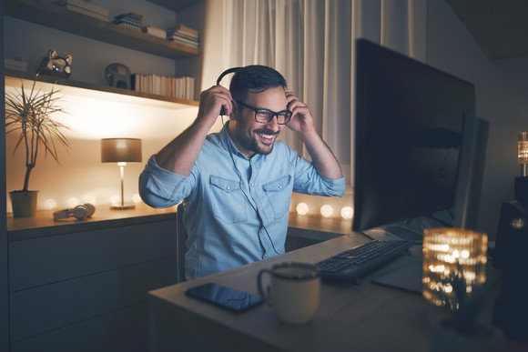 A man uses a PC in a home office.