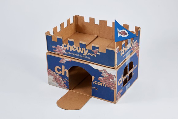Chewy-labeled boxes cut out to make a pet castle.