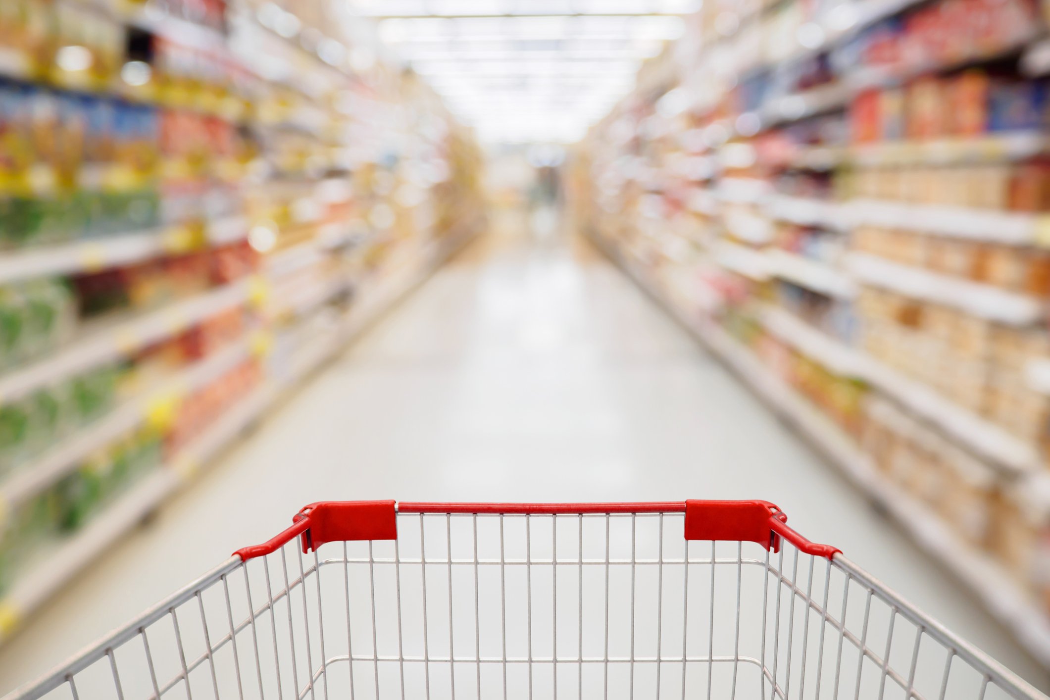 A shopping cart in a grocery aisle.