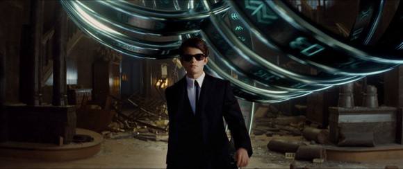A screenshot from Disney's "Artemis Fowl" showing a young kid wearing a black suit and sunglasses.