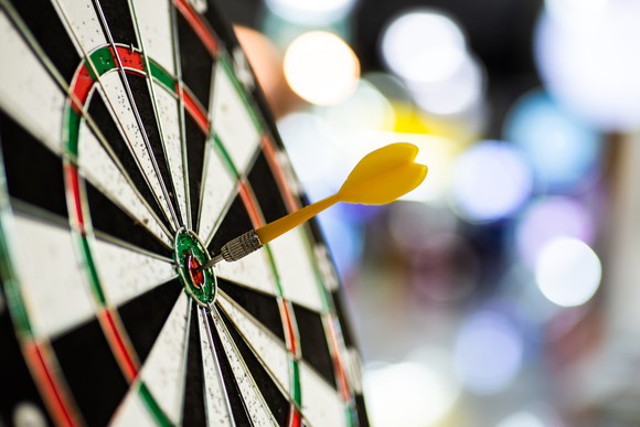 dart arrow hitting in the target center of dartboard