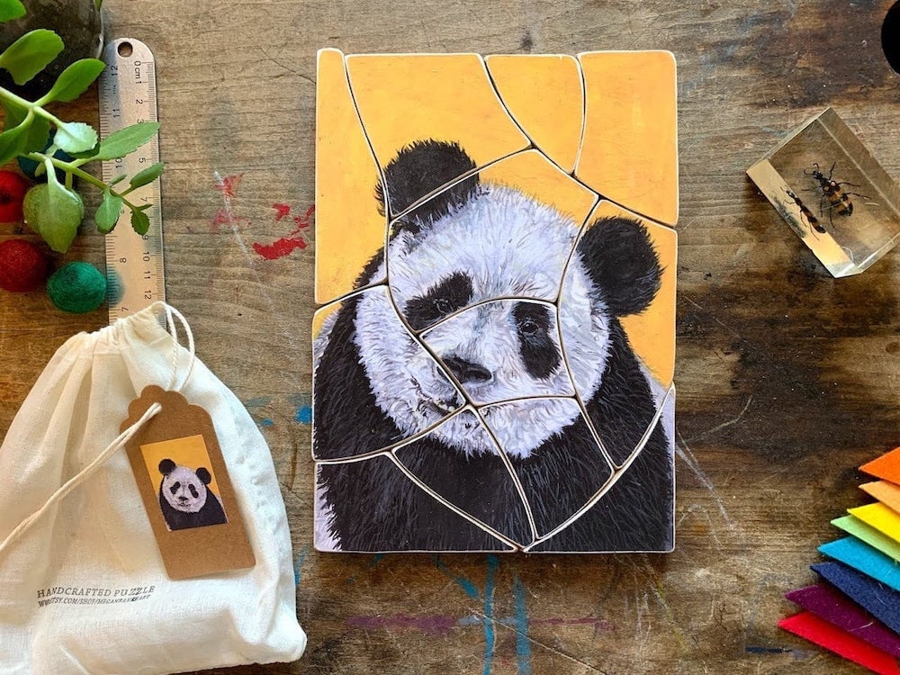 A 12-piece panda puzzle against a wood background