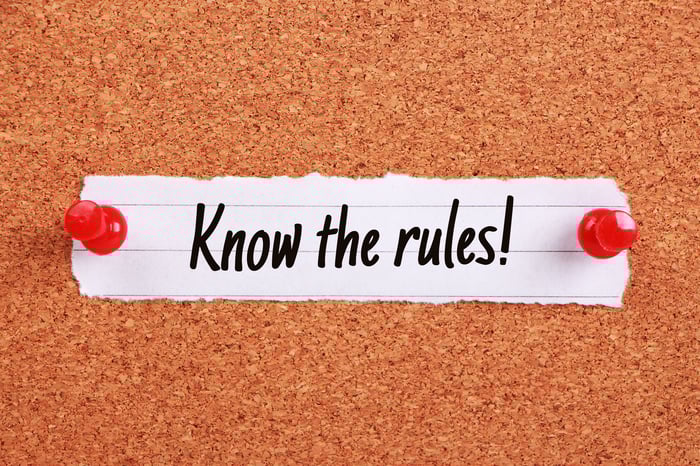 On corkboard, a scrap of paper is pinned, saying, "Know the rules!"