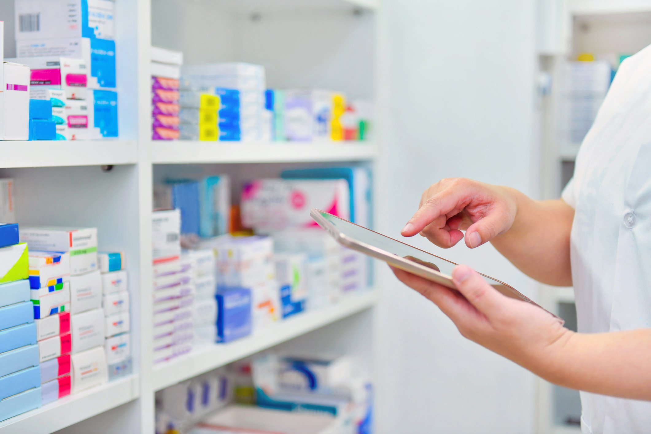 Worker using a tablet computer in a pharmacy.