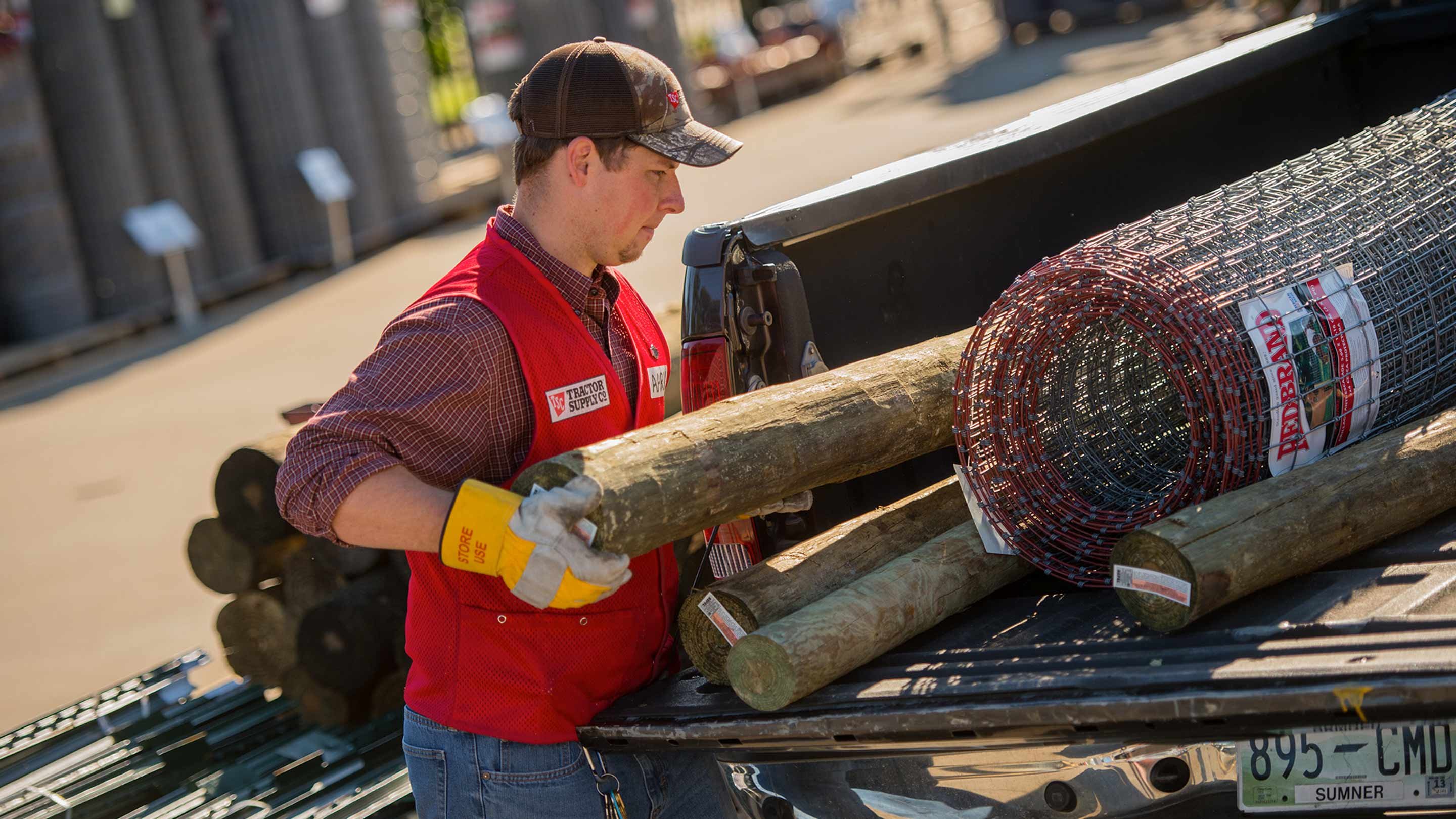 A Tractor Supply worker loading a truck.