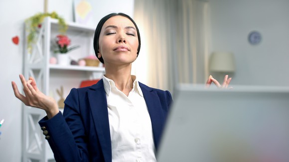 Woman meditating in home office