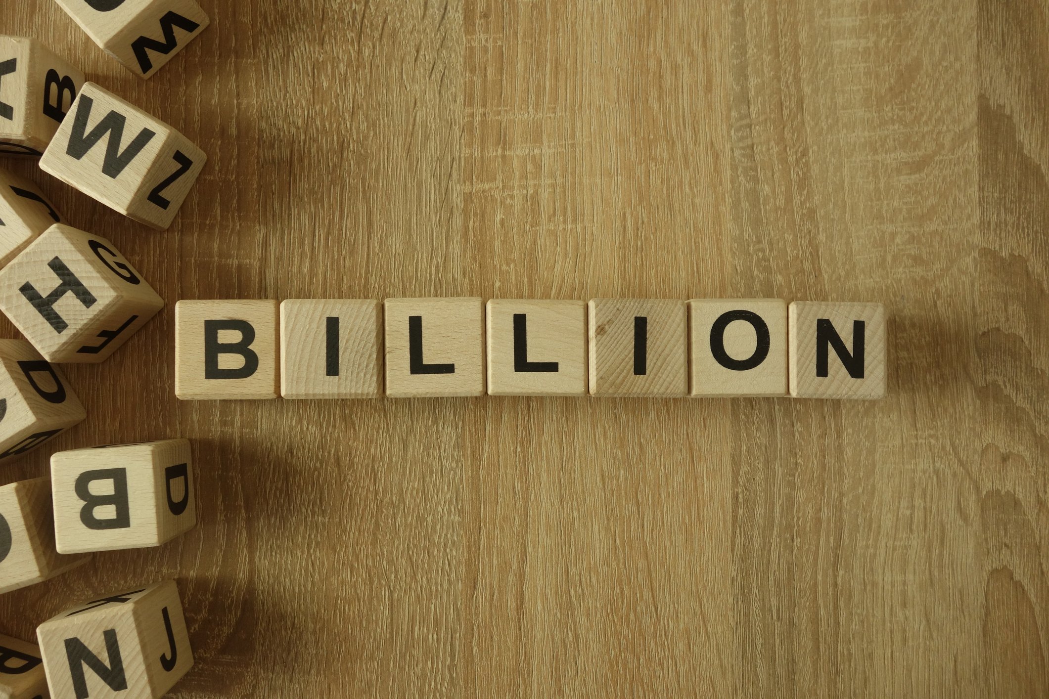 Wooden blocks on a table that spell the word billion.
