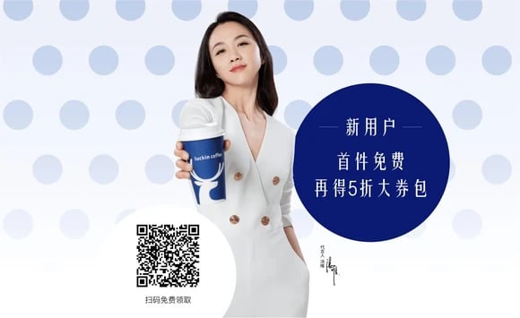 Person holding out a cup of coffee in a Luckin-logoed cup.