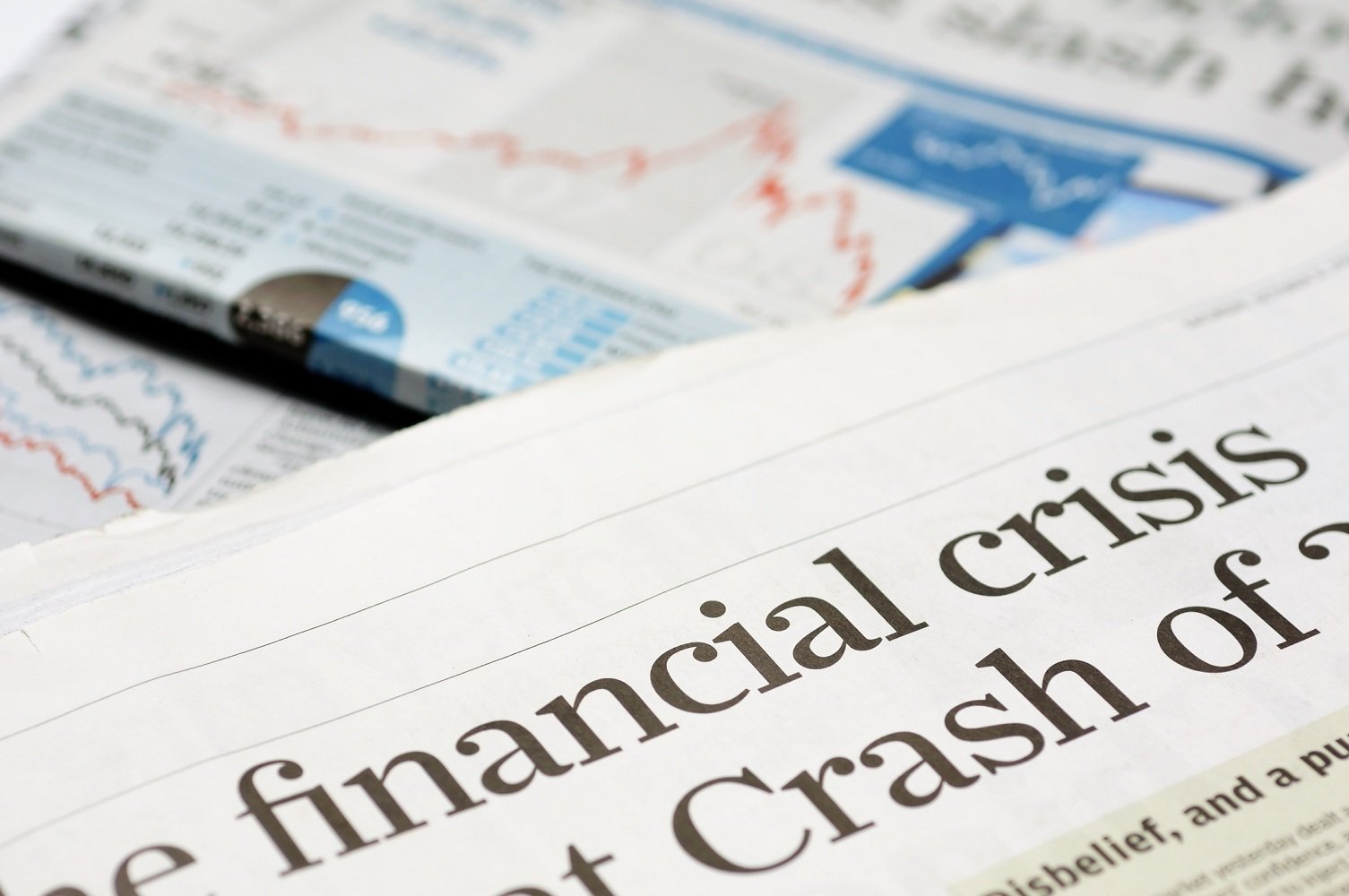 Newsprint with headlines that read financial crisis and crash.