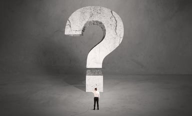 Man in front of big question mark