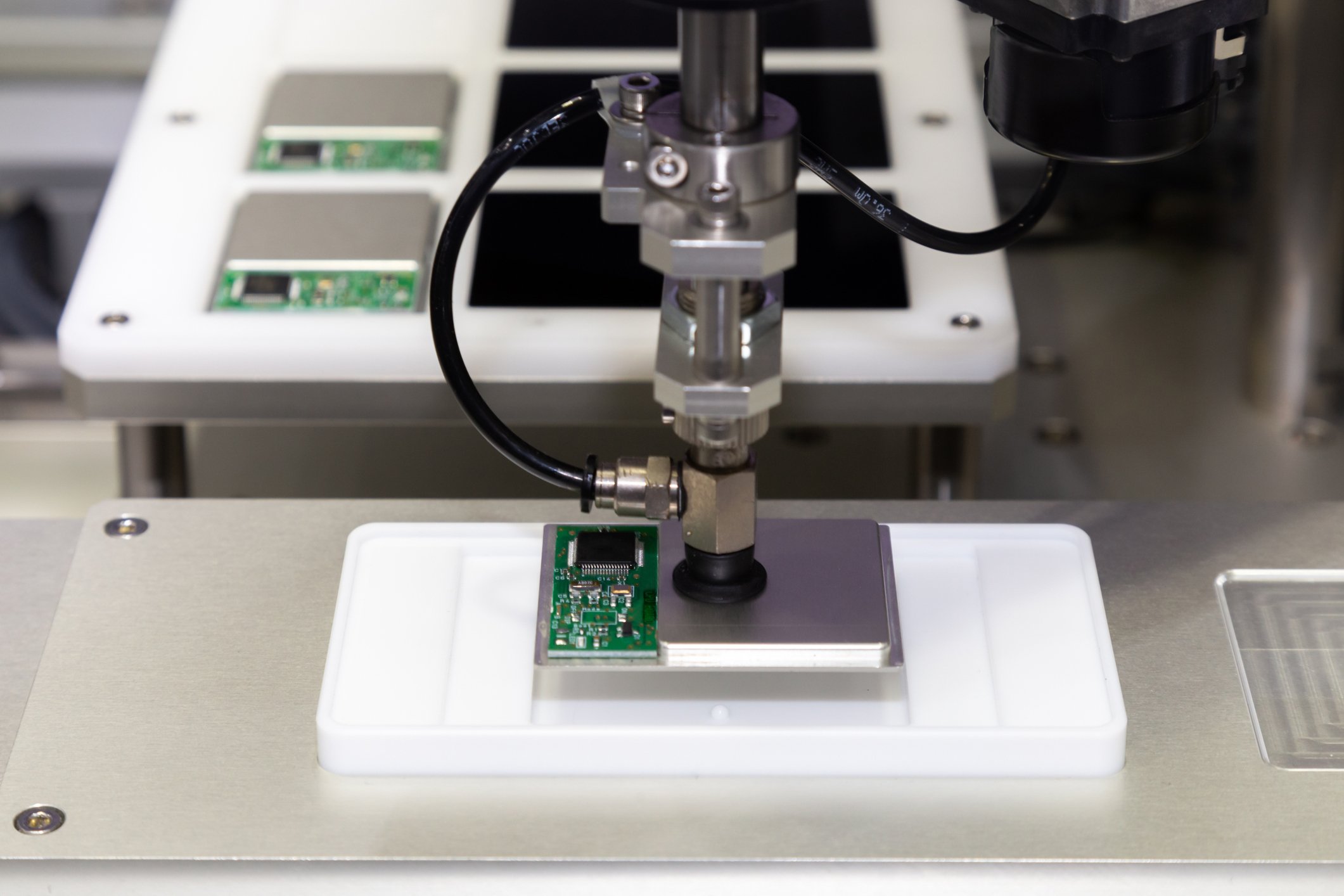 Robot arm with vacuum working on a smartphone chip.