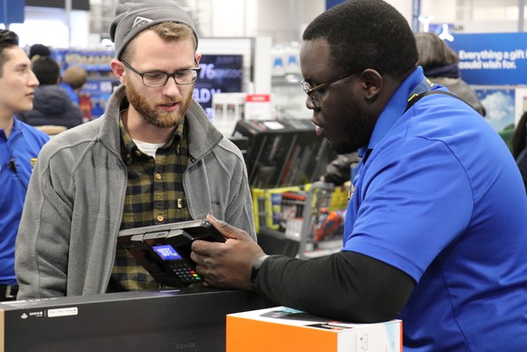 Best Buy employee assisting a customer.