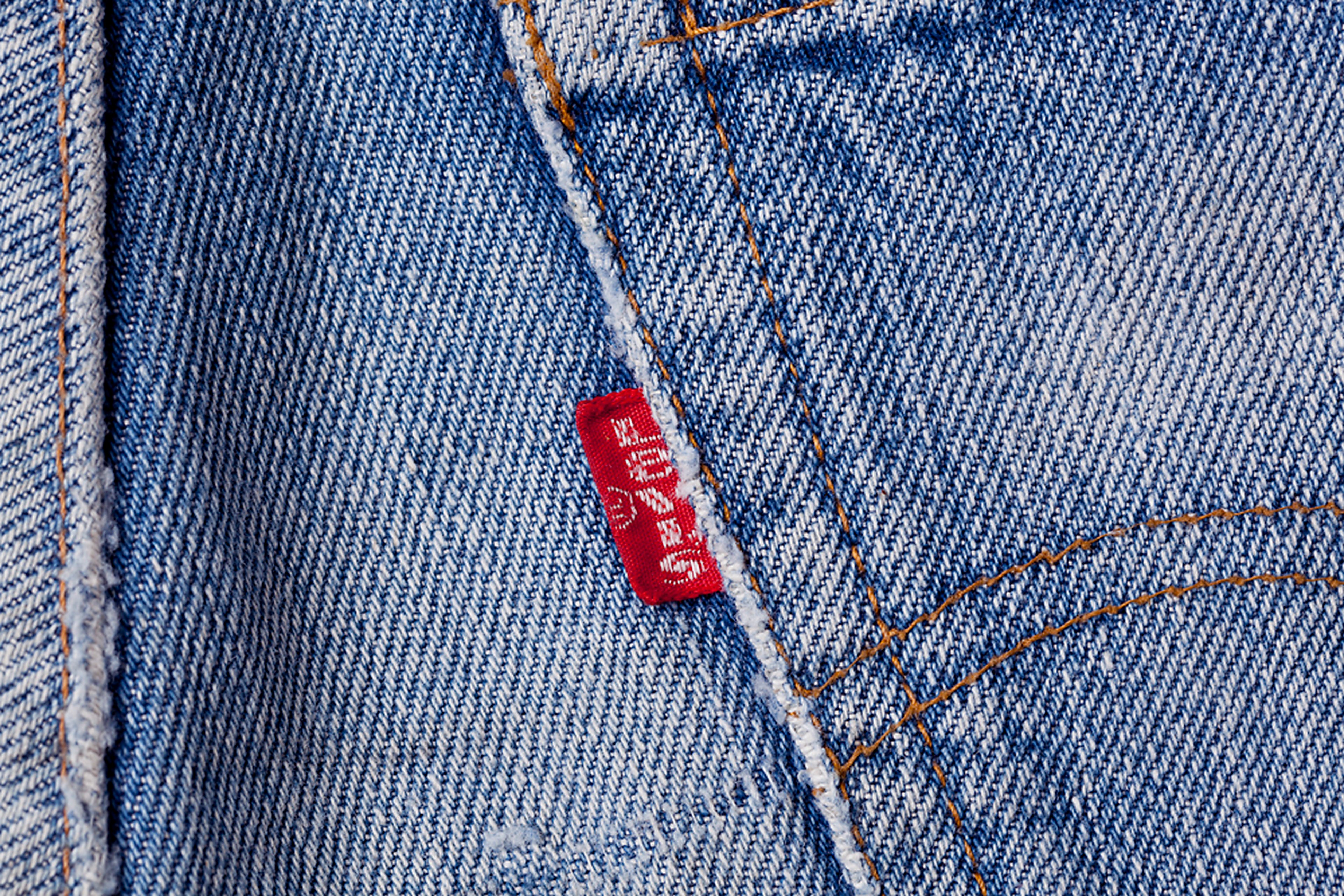 A back pocket of a pair of jeans with the Levi's red tab stitched into the seam.