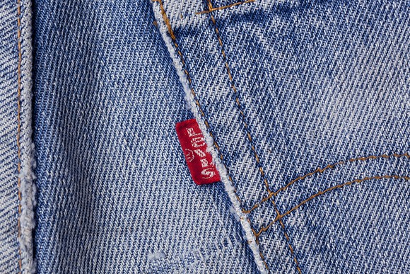 A back pocket of a pair of jeans with the Levi's red tab stitched into the seam.