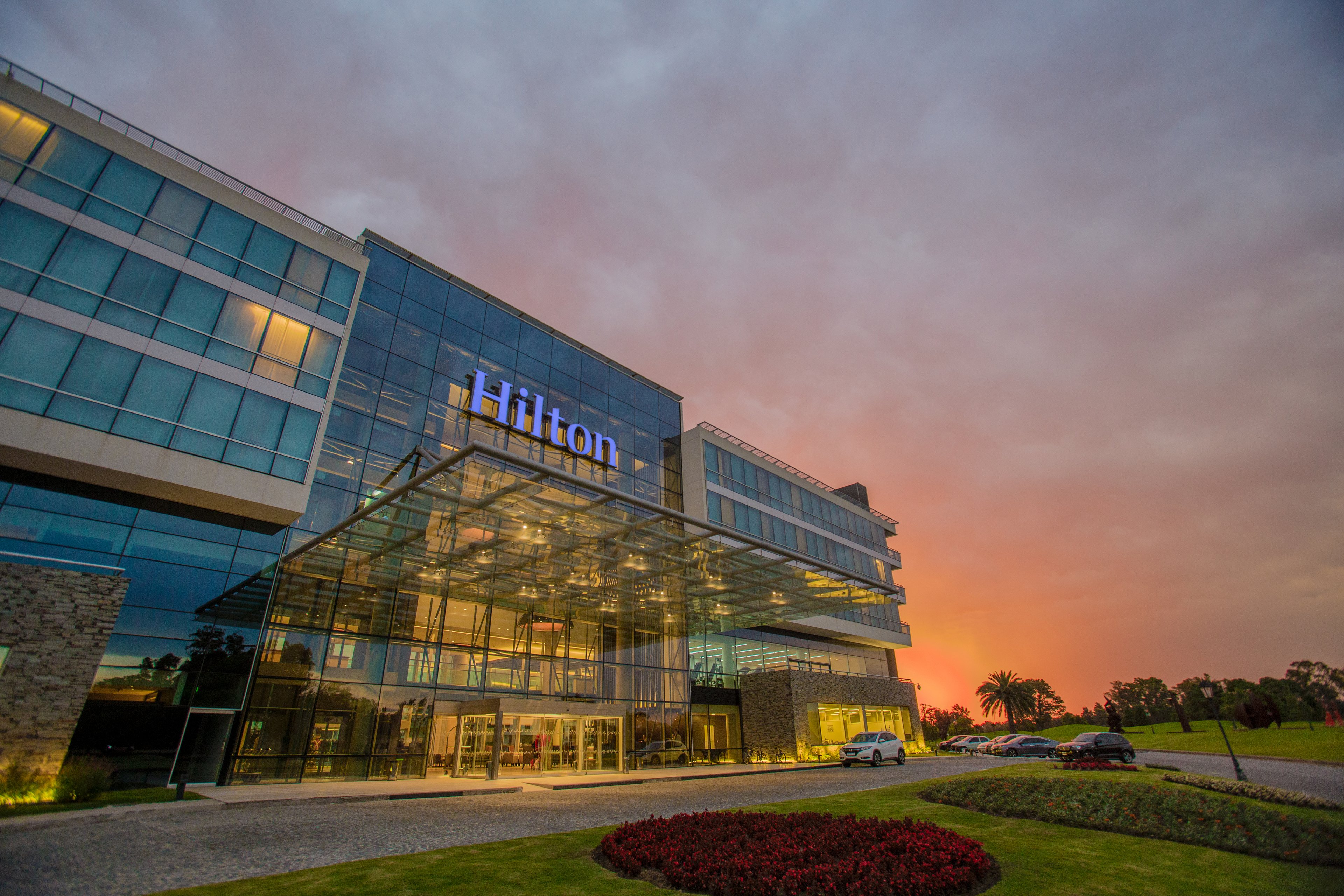 The exterior of the Hilton Pilar against a sunset.
