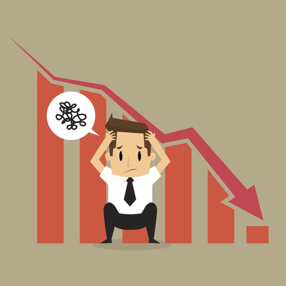Cartoon man clutching head in front of dropping stock chart