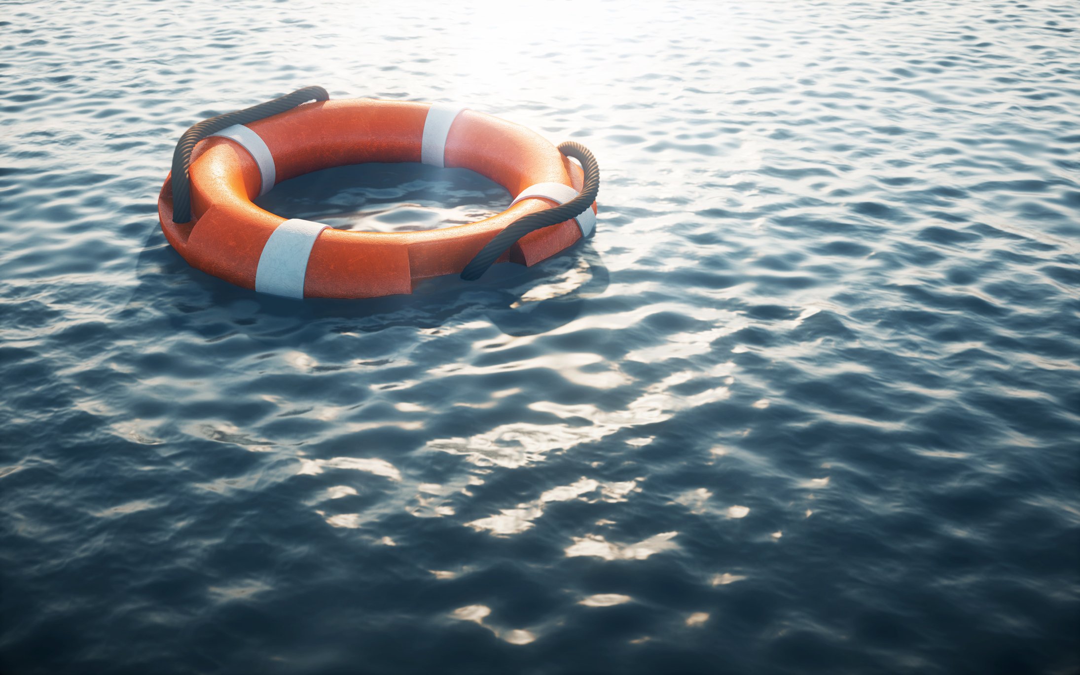 Life preserver floating on empty ocean water.
