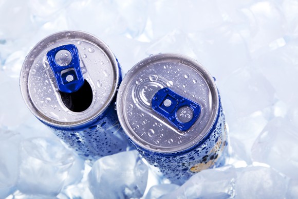 Two energy drinks surrounded by ice cubes