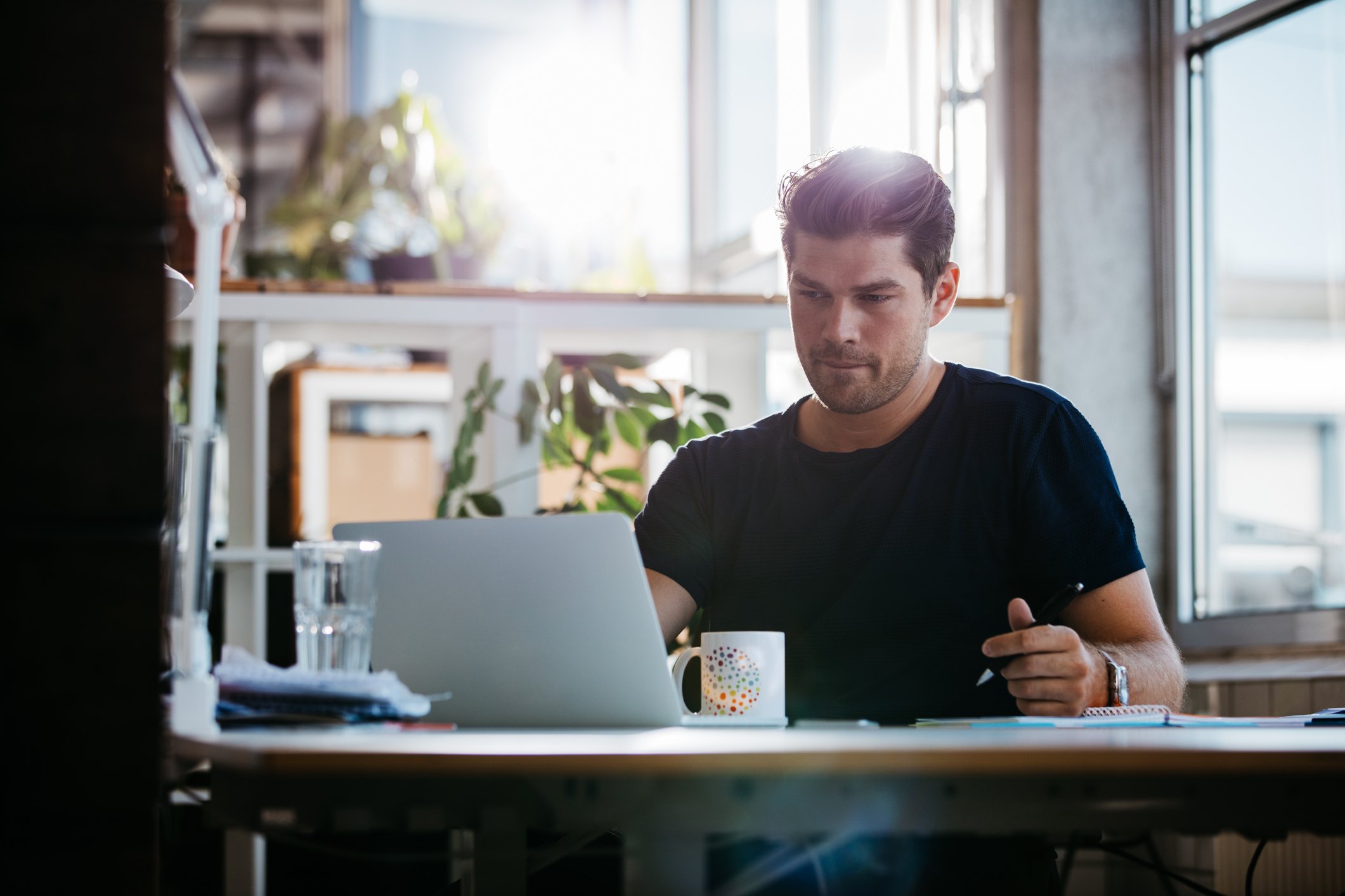 Man with serious expression at laptop.