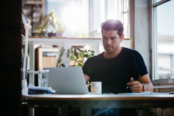 Man with serious expression at laptop.