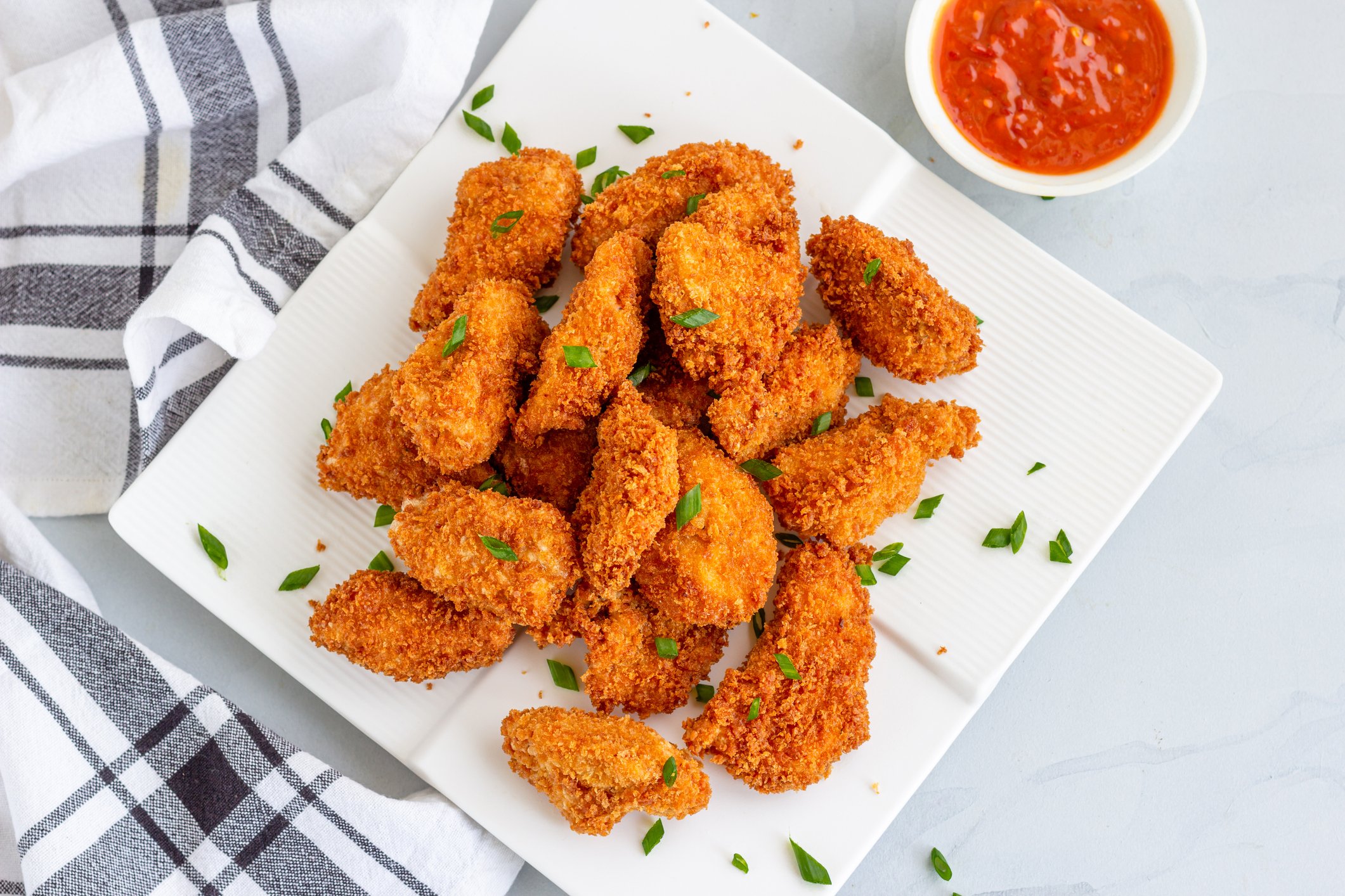 Chicken nuggets on a square plate.