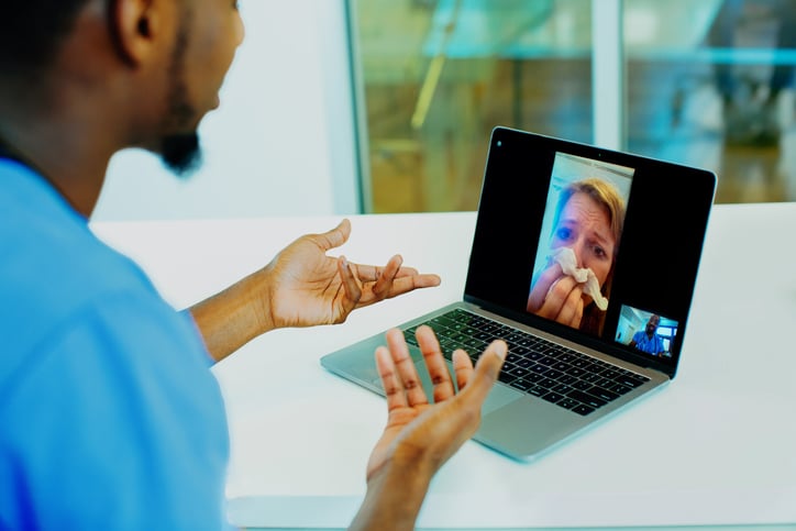 A woman talking to a nurse via telemedicine.