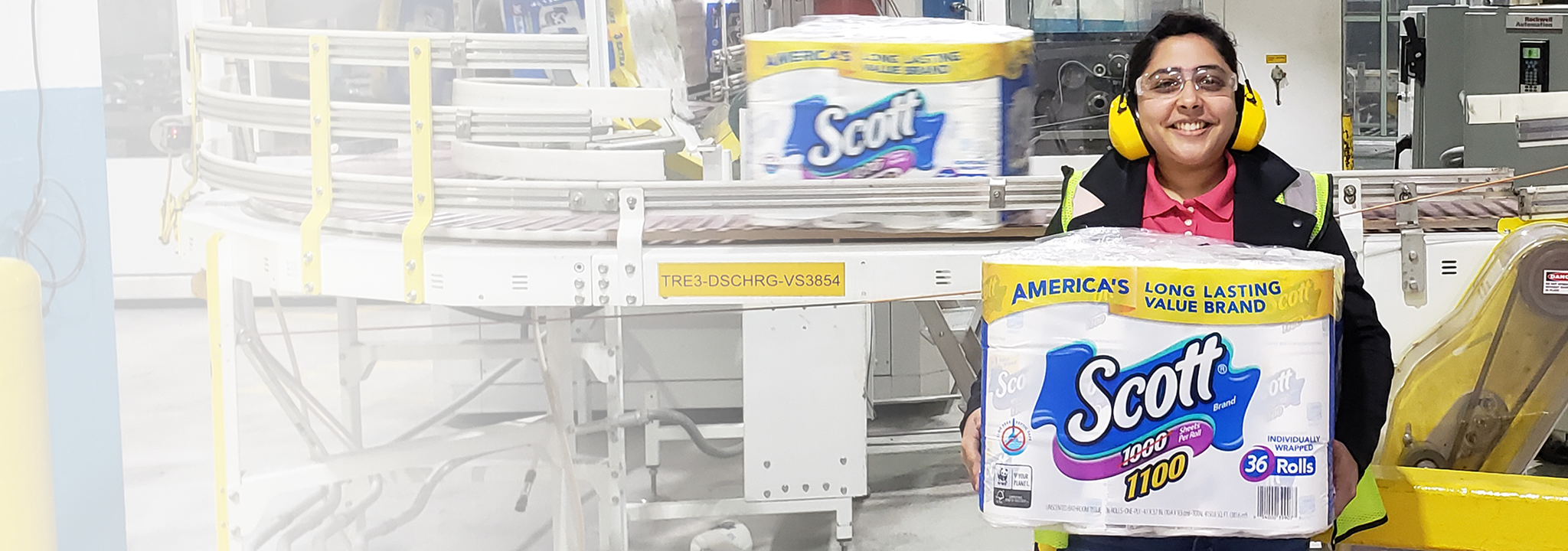 Kimberly-Clark worker with pack of Scott bathroom tissue.