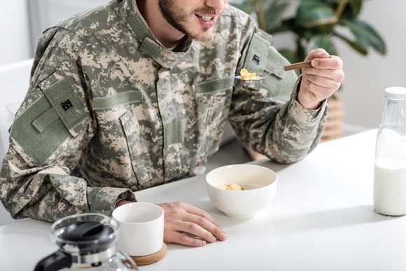 Soldier in camouflage eating breakfast.