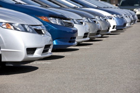 A closeup view of the hoods of several cars parked side by side