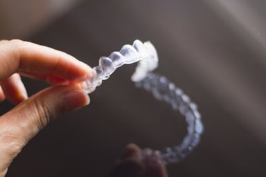 Hand holding clear aligner