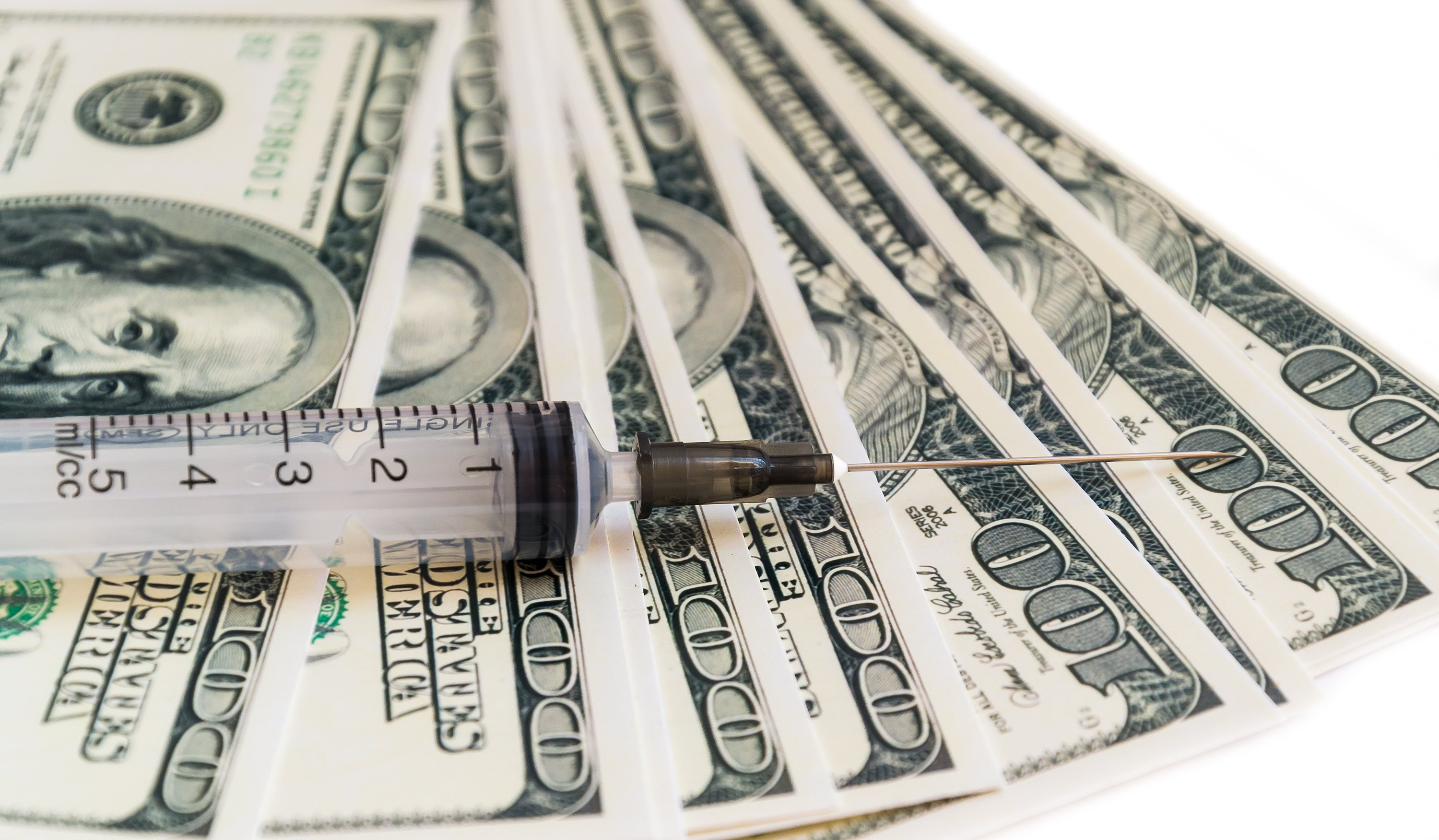 Syringe on top of $100 bills