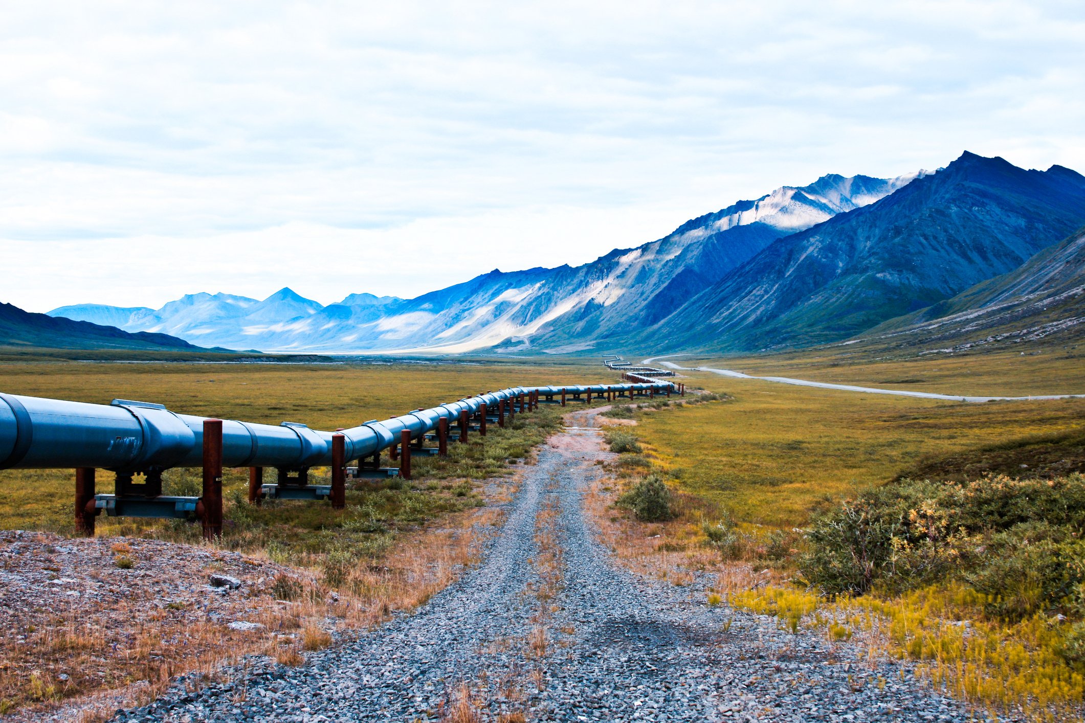 alaska oil pipeline with mountains in the background