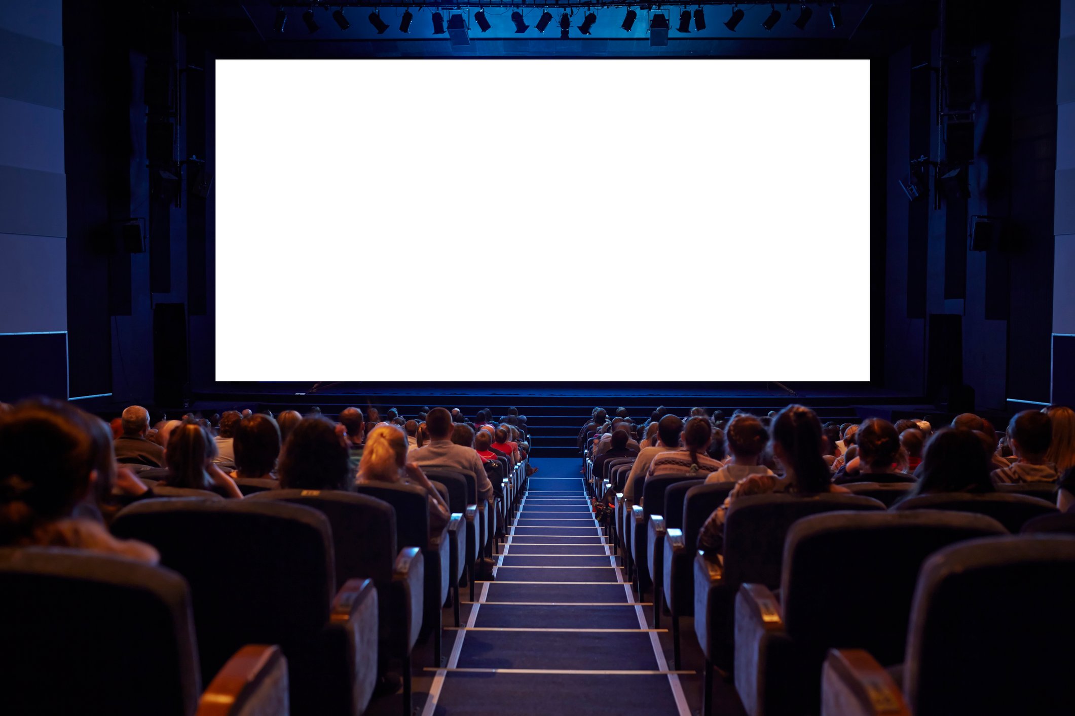 People seated in a movie theater facing a blank screen.