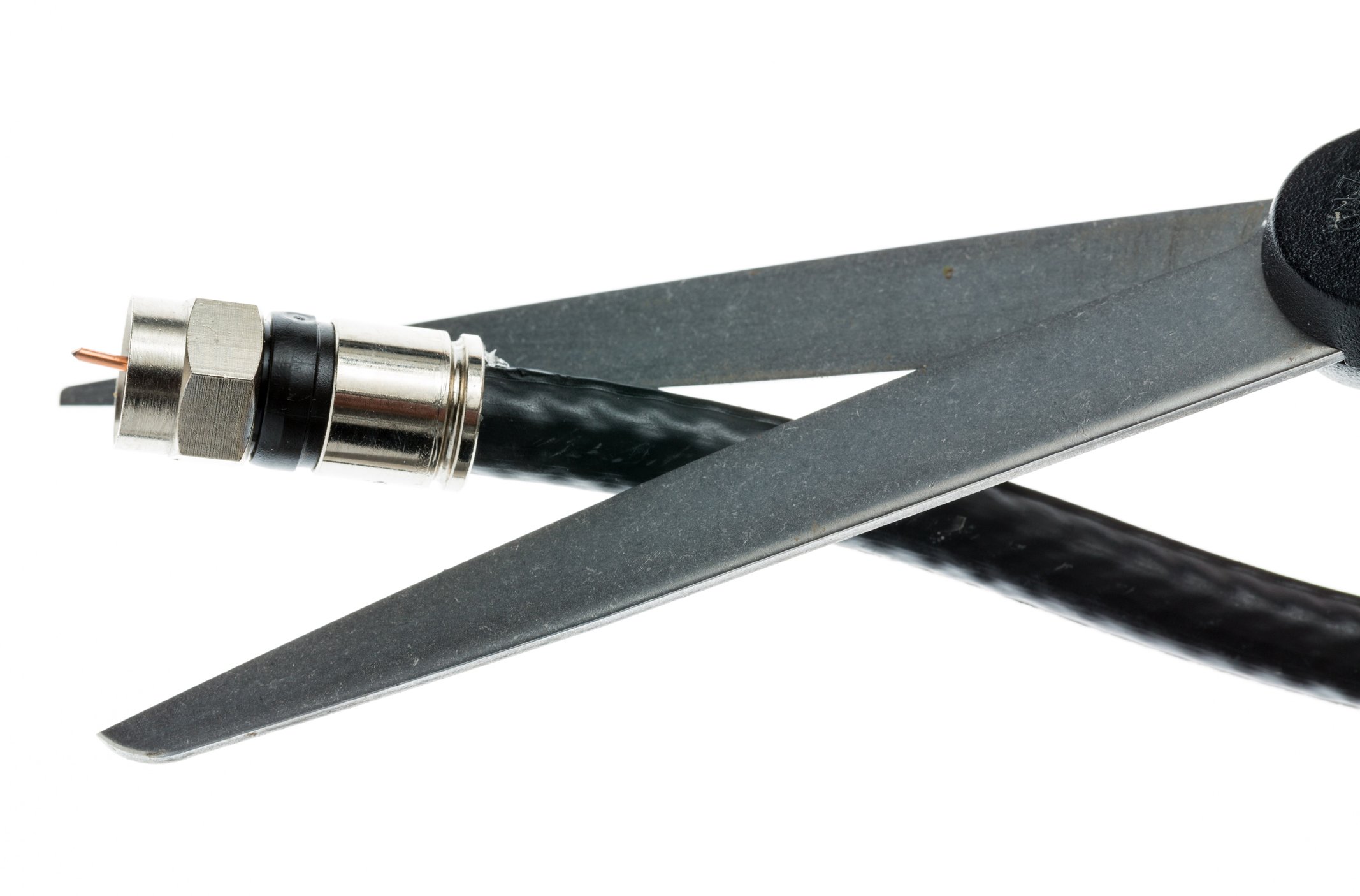 A pair of scissors about to cut through a coaxial cable