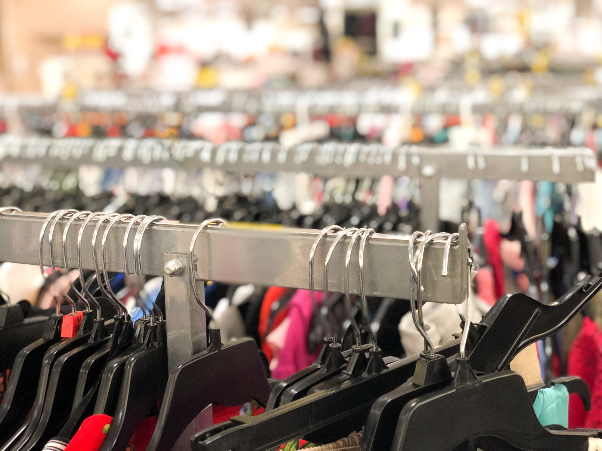 An up-close view of hangers with women's clothing on a rack is shown.