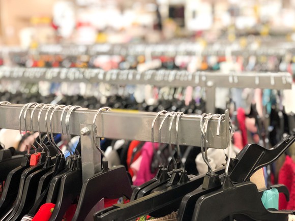 An up-close view of hangers with women's clothing on a rack is shown.