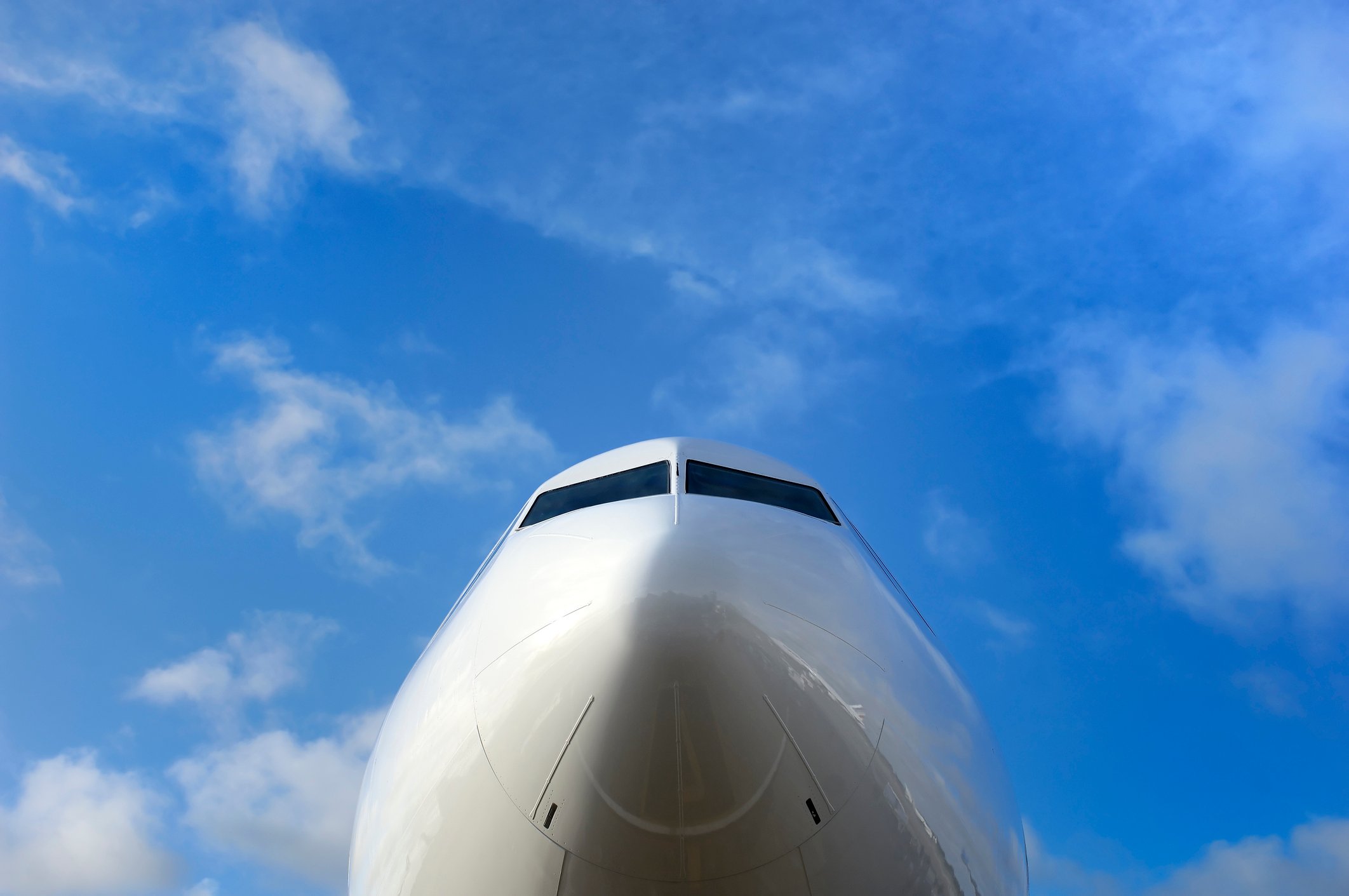 The nose of a jet with a bright blue sky in the background