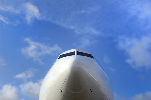 The nose of a jet with a bright blue sky in the background