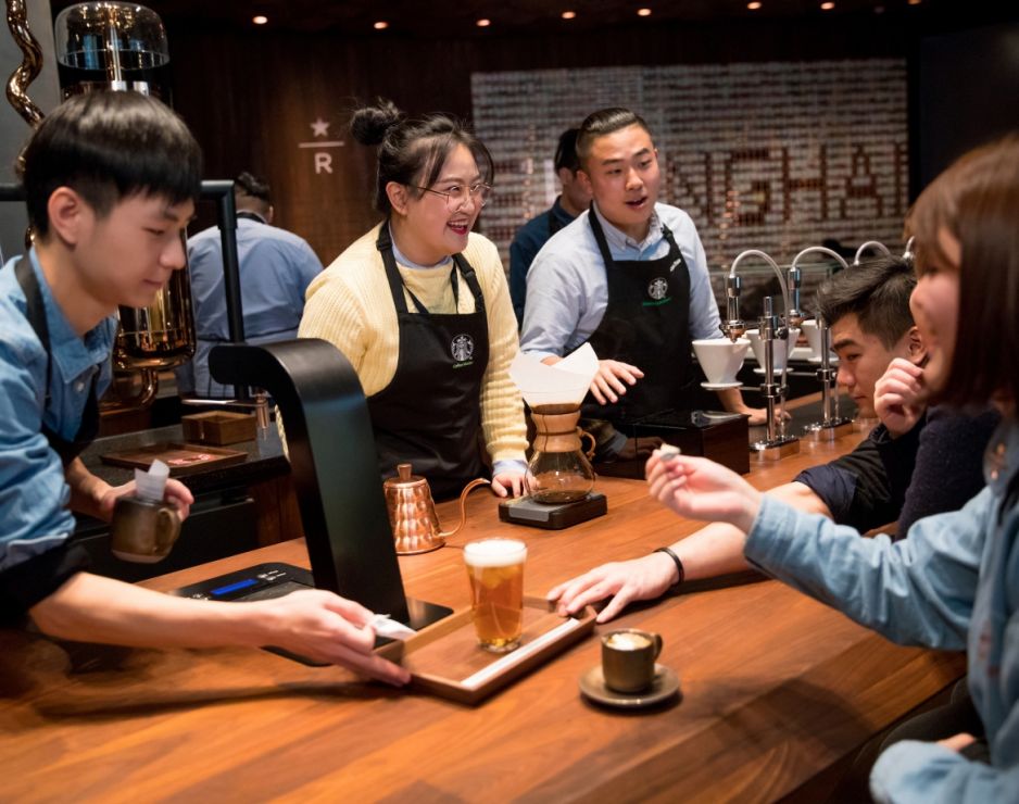 A group of Starbucks workers in China talking around a table.