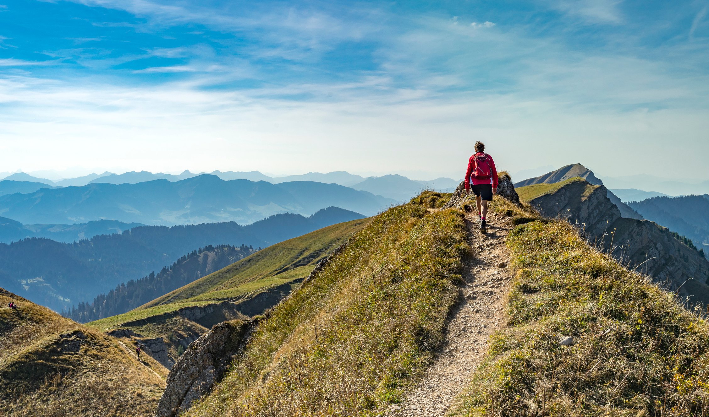 A lone hiker walking up a mountain trail